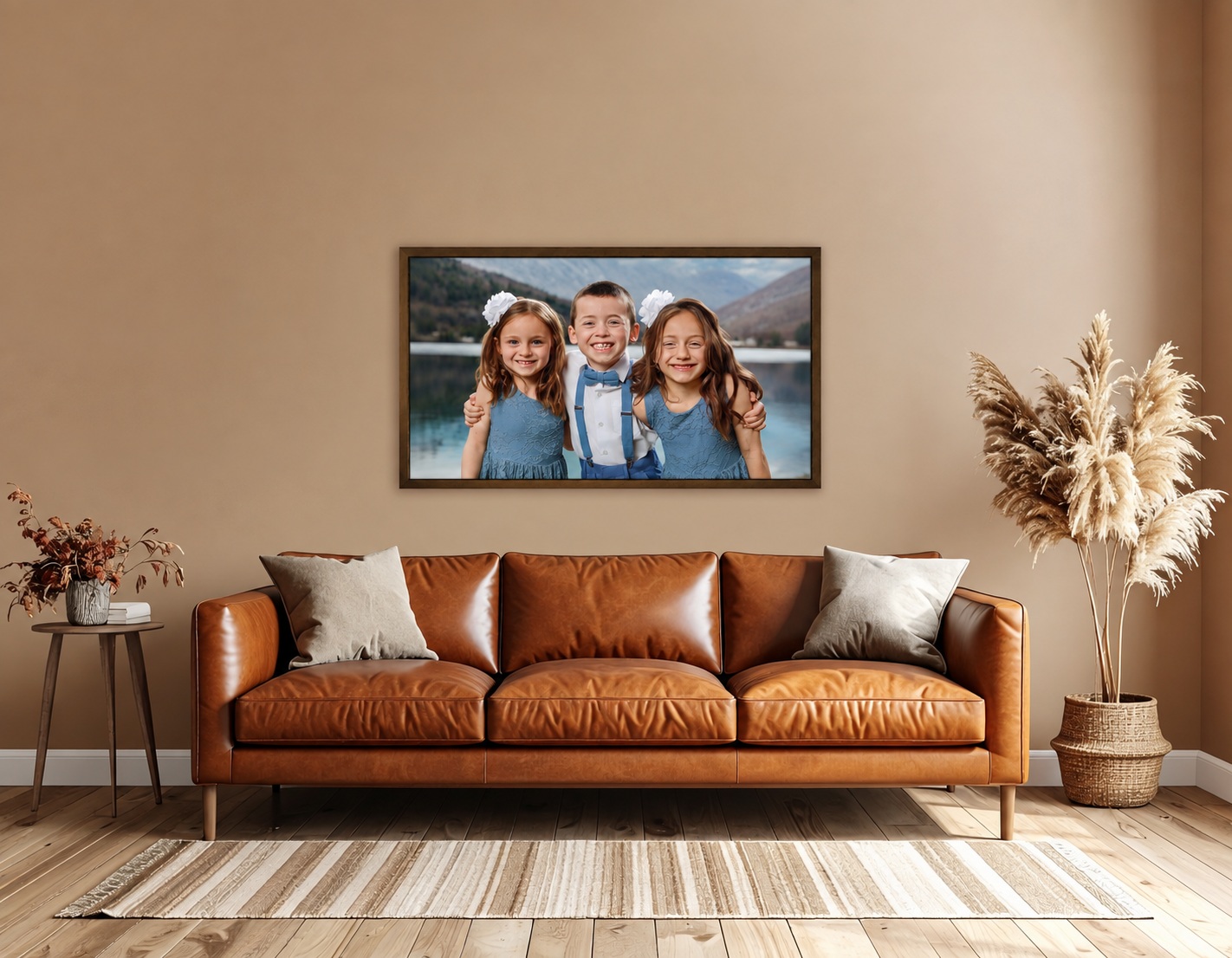 A framed portrait of three children above a warm brown leather couch